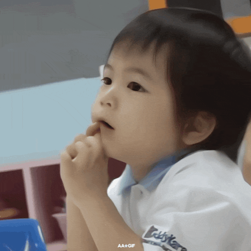 a little boy wearing a teddy bears shirt looks to the side