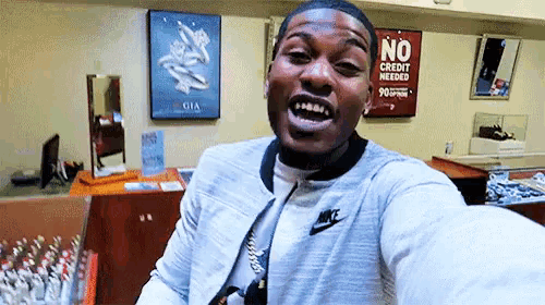 a man taking a selfie in front of a no credit needed sign
