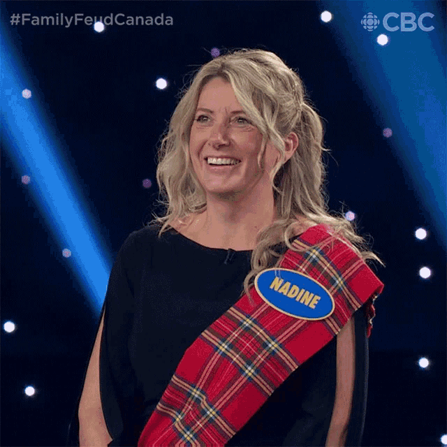 a woman wearing a plaid sash with a name tag that says nadine on it