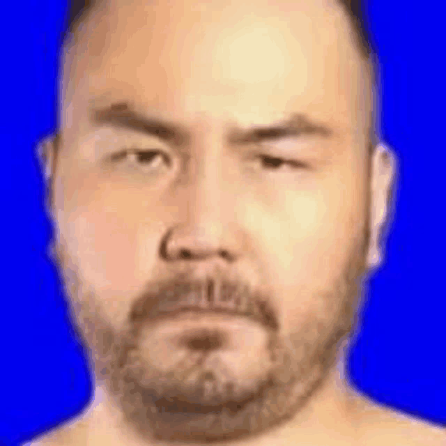 a bald man with a beard is making a funny face .