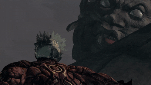 a man is standing in front of a statue of a monster