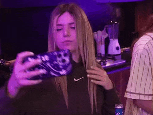 a woman is taking a selfie with a cell phone .