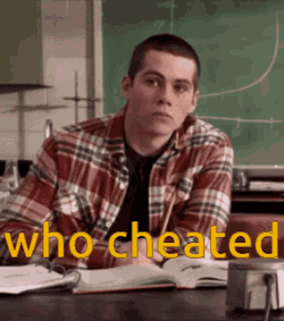a man in a plaid shirt is sitting at a desk in front of a chalkboard with the words who cheated written on it