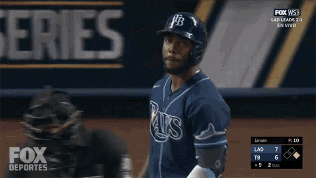 a baseball player in a rays jersey is holding a bat