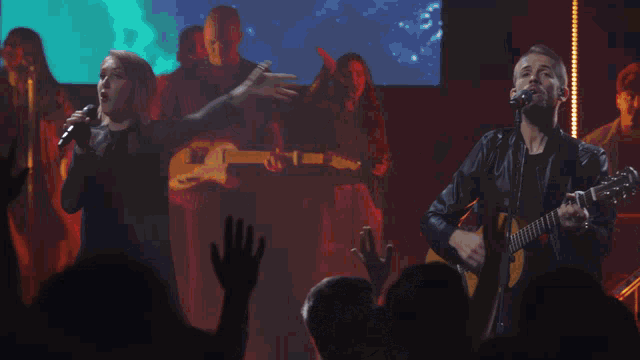 a crowd of people at a concert with their hands up