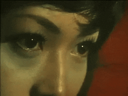 a close up of a woman 's eyes with red lenses .