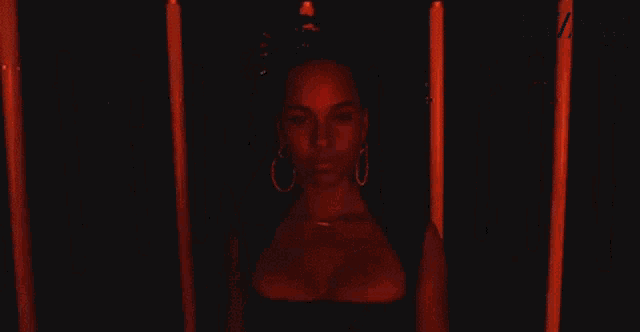 a woman is standing in front of a bunch of red lights .