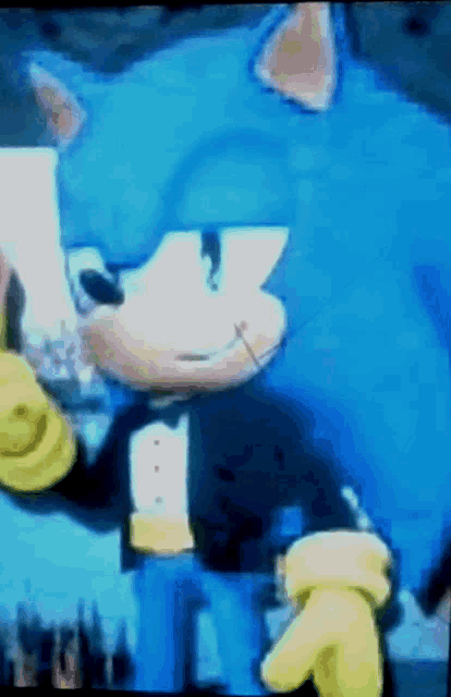a close up of a sonic the hedgehog in a tuxedo and yellow gloves
