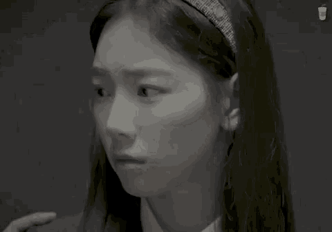 a girl with a headband on her head looks down at something