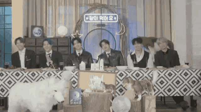 a group of people are sitting at a table with a dog and a white sheep .