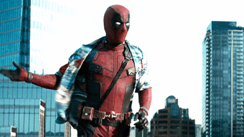 a man in a deadpool costume is standing in front of tall buildings