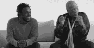 two men are sitting next to each other on a couch .