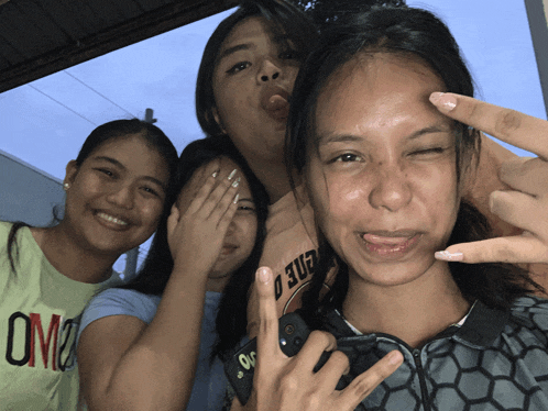 four girls posing for a picture with one wearing a shirt that says ' um2 ' on it
