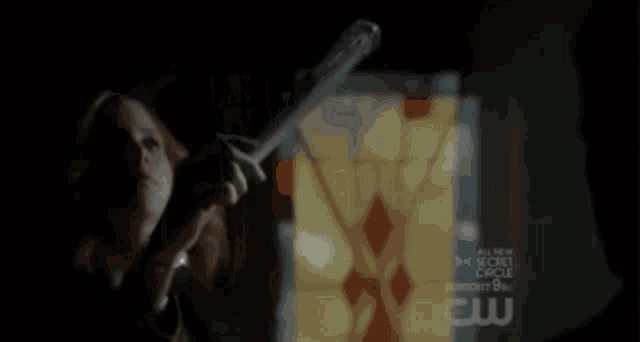 a woman is holding a wand in front of a screen that says the secret circle on it