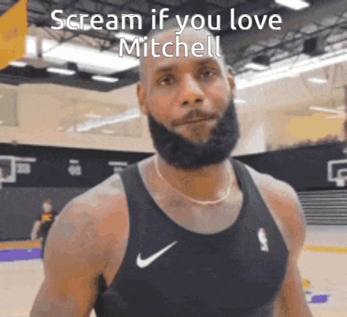 a man with a beard is wearing a black nike tank top and screaming if you love mitchell .