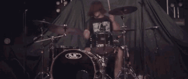 a man is playing a s & c drum set