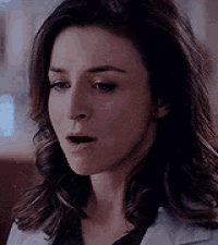 a close up of a woman 's face with her mouth open and a serious look on her face .