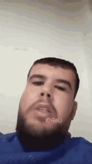 a man with a beard is making a funny face .