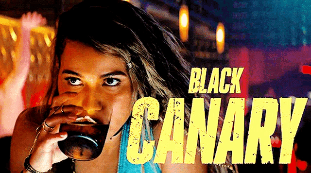 a woman drinking from a glass with the words black canary written on it