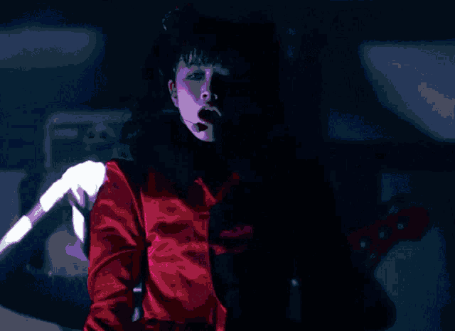 a woman in a red dress is dancing in front of a babymetal logo