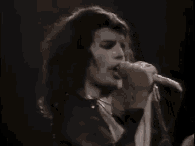 a close up of a person singing into a microphone on a stage .