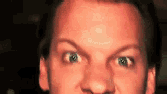 a close up of a man 's face with green eyes .
