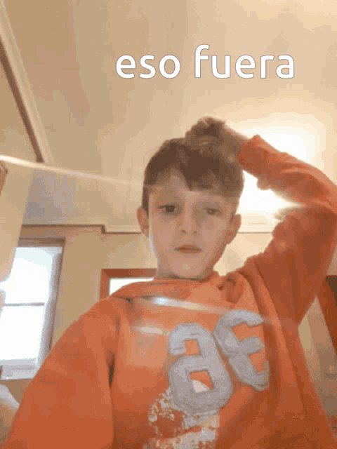 a young boy in an orange sweatshirt with the number 86 on it