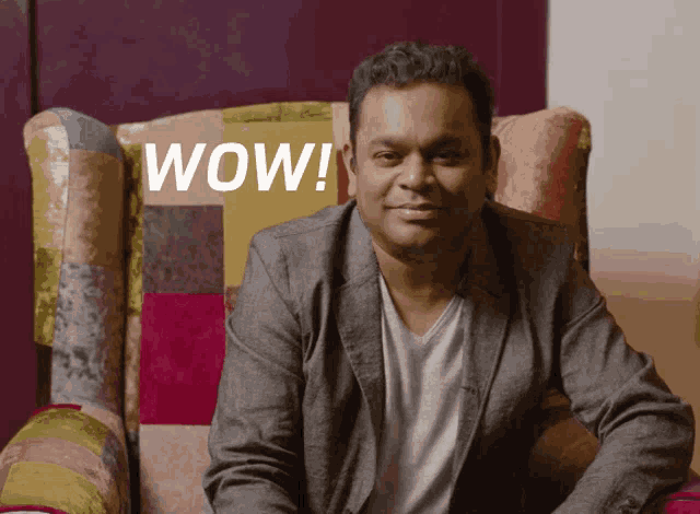 a man in a suit sits in a chair with the words wow written on the back