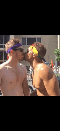 two shirtless men are kissing each other while wearing rainbow headbands