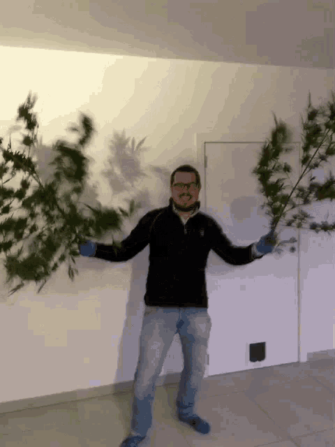 a man in a black sweater and blue socks is holding a plant