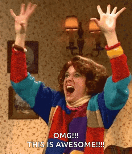 a woman in a colorful sweater is raising her arms in the air and says omg this is awesome !!!