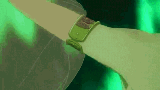 a close up of a person 's wrist with a green bracelet on it .