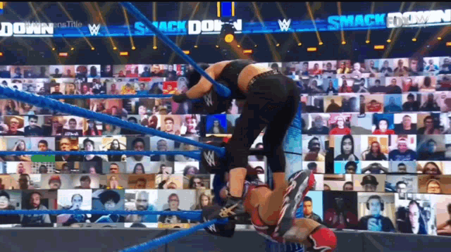 a wrestling match is going on in front of a crowd with the words smack down on the bottom