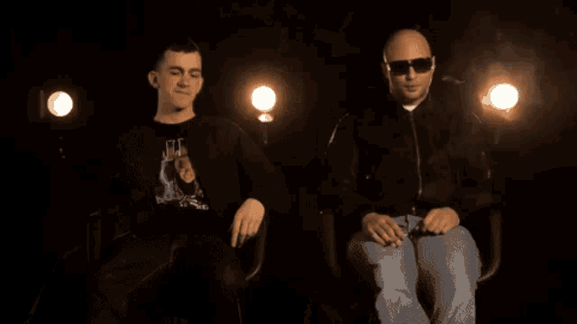 a man wearing sunglasses is smoking a cigarette in the dark
