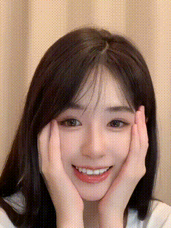 a close up of a woman with her hands on her face .