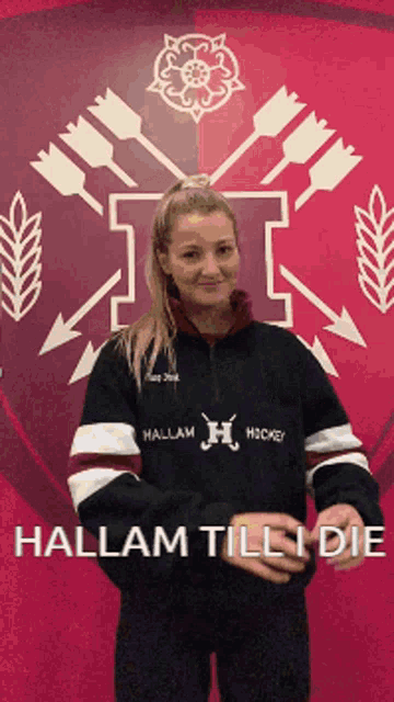 a woman standing in front of a wall with arrows and a t on it