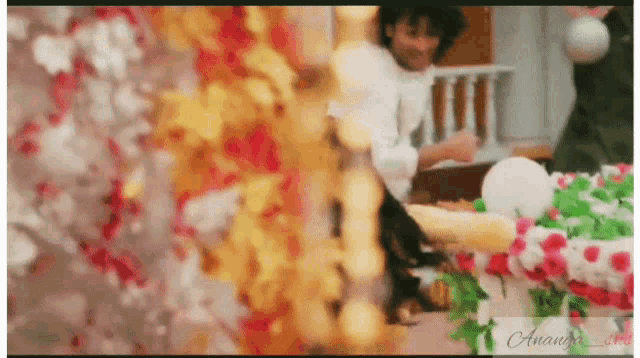 a blurry picture of a man standing next to a table with flowers