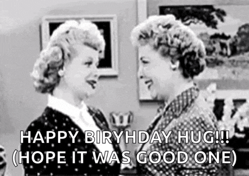 a black and white photo of two women standing next to each other and talking .