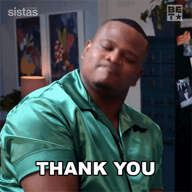 a man in a green shirt is giving a thank you gesture