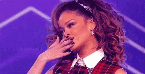 a woman is covering her face with her hand while wearing a plaid shirt and tie .