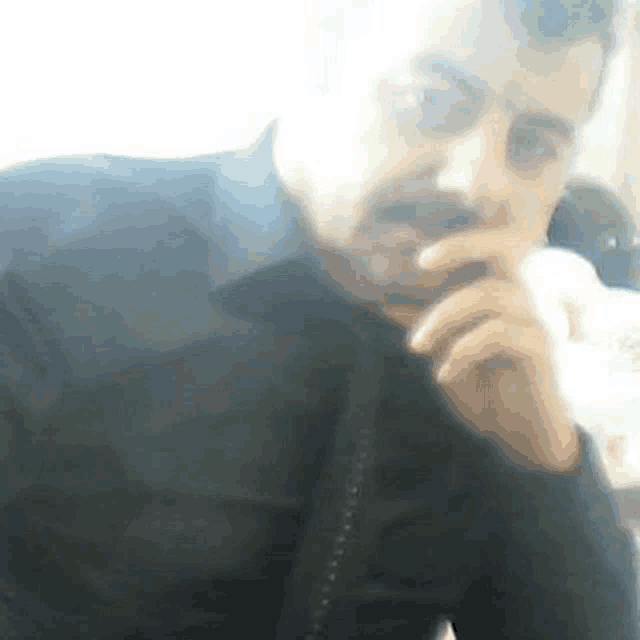 a man with a mustache is talking on a cell phone .