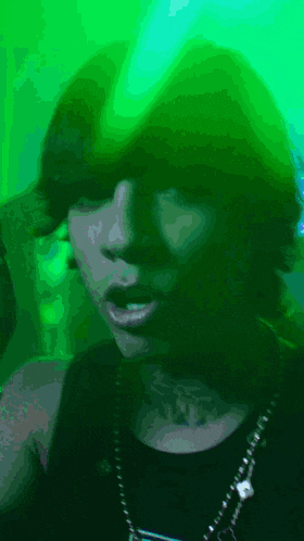 a woman with a tattoo on her neck is wearing a green hat