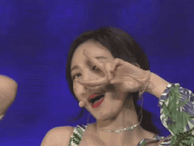 a woman is making a peace sign with her hands