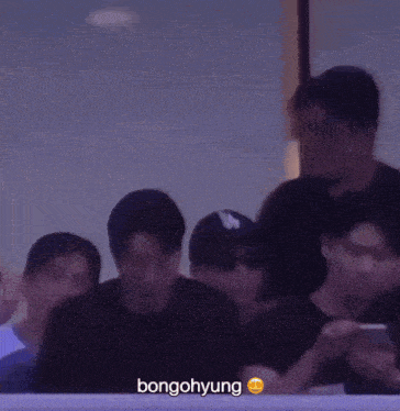 a group of people are sitting in a dark room with bongohyung written on the screen