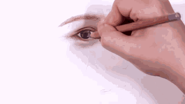 a person is drawing a woman 's eye with a pencil on a piece of paper .