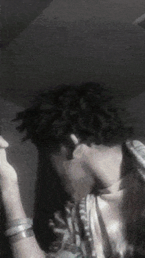 a man with dreadlocks covering his face with his hands