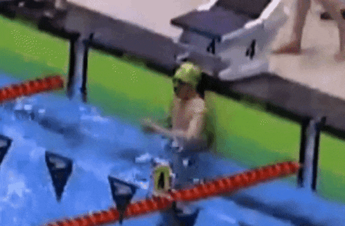 a person is swimming in a pool with a number 4 on the side of the pool .