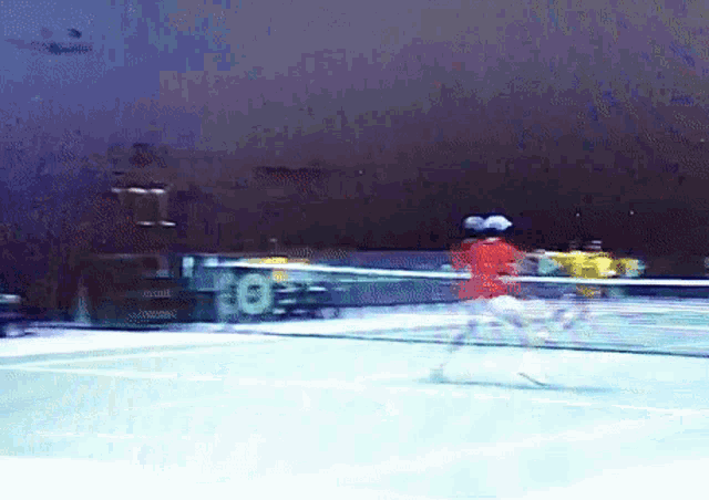 a blurred image of a tennis match with the number 8 on the wall
