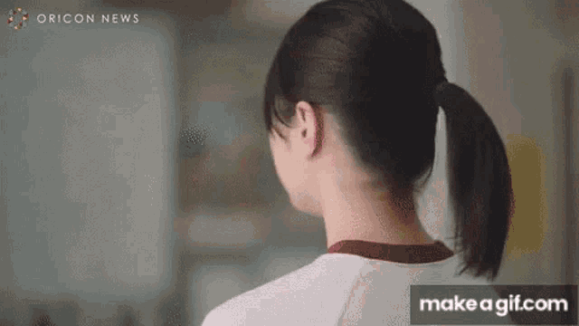 a woman is wearing a ponytail and looking at the camera .