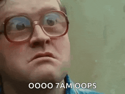 a man wearing glasses and a blue shirt is making a funny face .